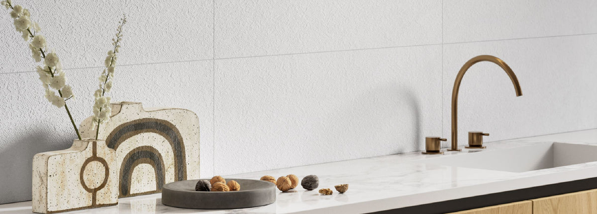 Modern kitchen with white tiles, a sink, and decorative elements.